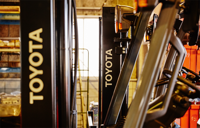 フォークリフトが並ぶ倉庫内の写真